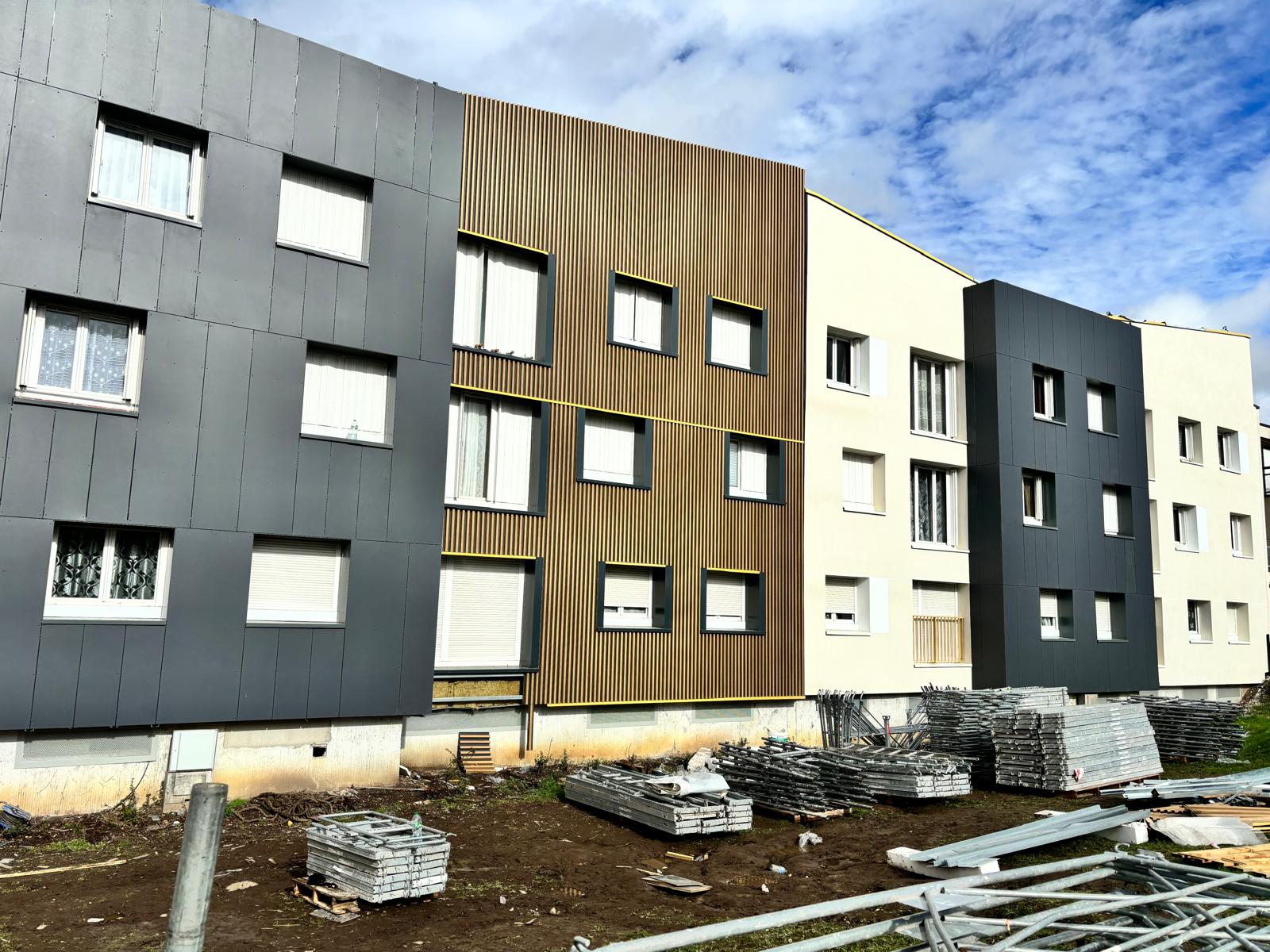 Bardage bicolore gris et rouge en cours de pose