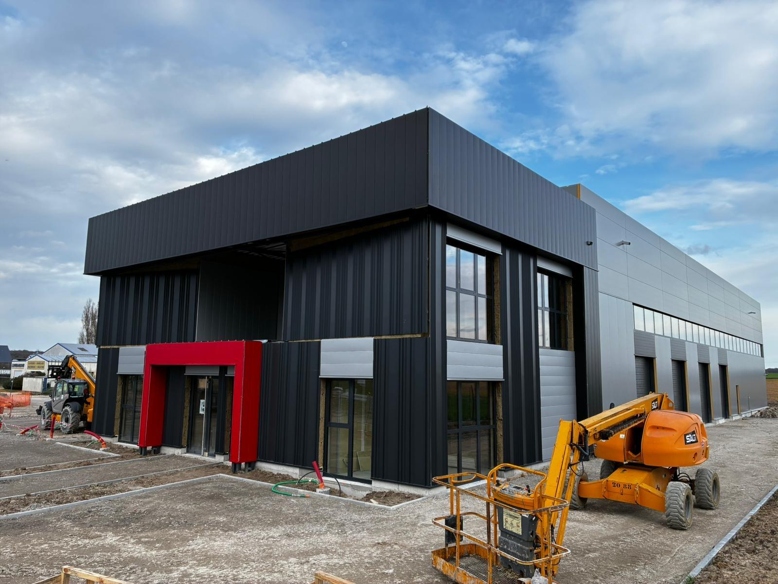 Batiment industriel avec bardage noir et entree rouge - OPTIBARDAGE