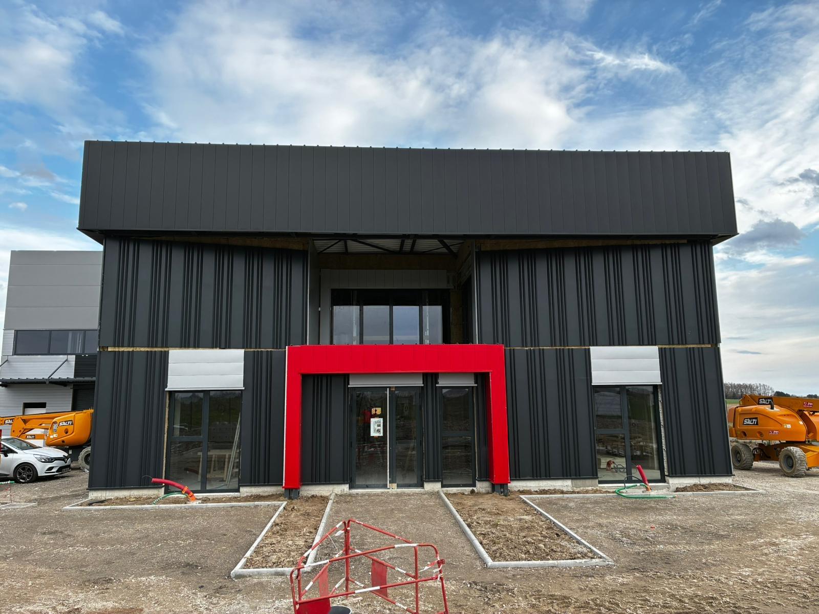 Façade acier noire avec entrée architecturale rouge